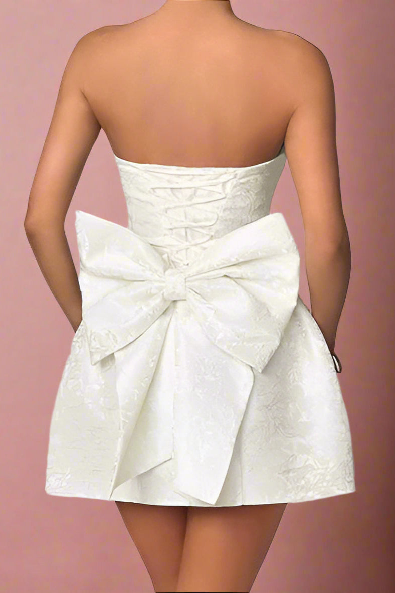 Amora White Strapless Structured Corseted Lace-up Hourglass Mini Wedding Dress with Satin Jacquard Fabric and Large Detachable Bow- back view by Orange Blossom Bridal
