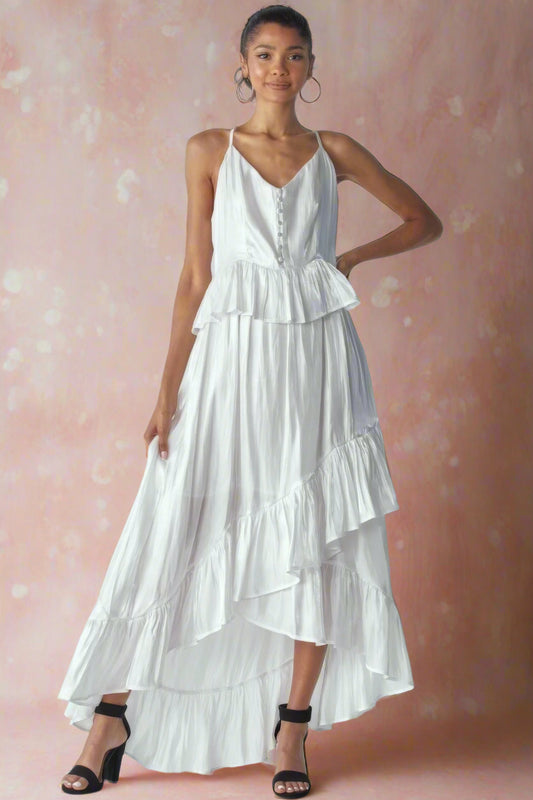 Ásta Modern Shimmering White Unstructured A-Line High-Low Maxi Wedding Dress With Spaghetti Straps, Ruffles, V-Neckline, Buttons, and Peplum Detail by Orange Blossom Bridal.