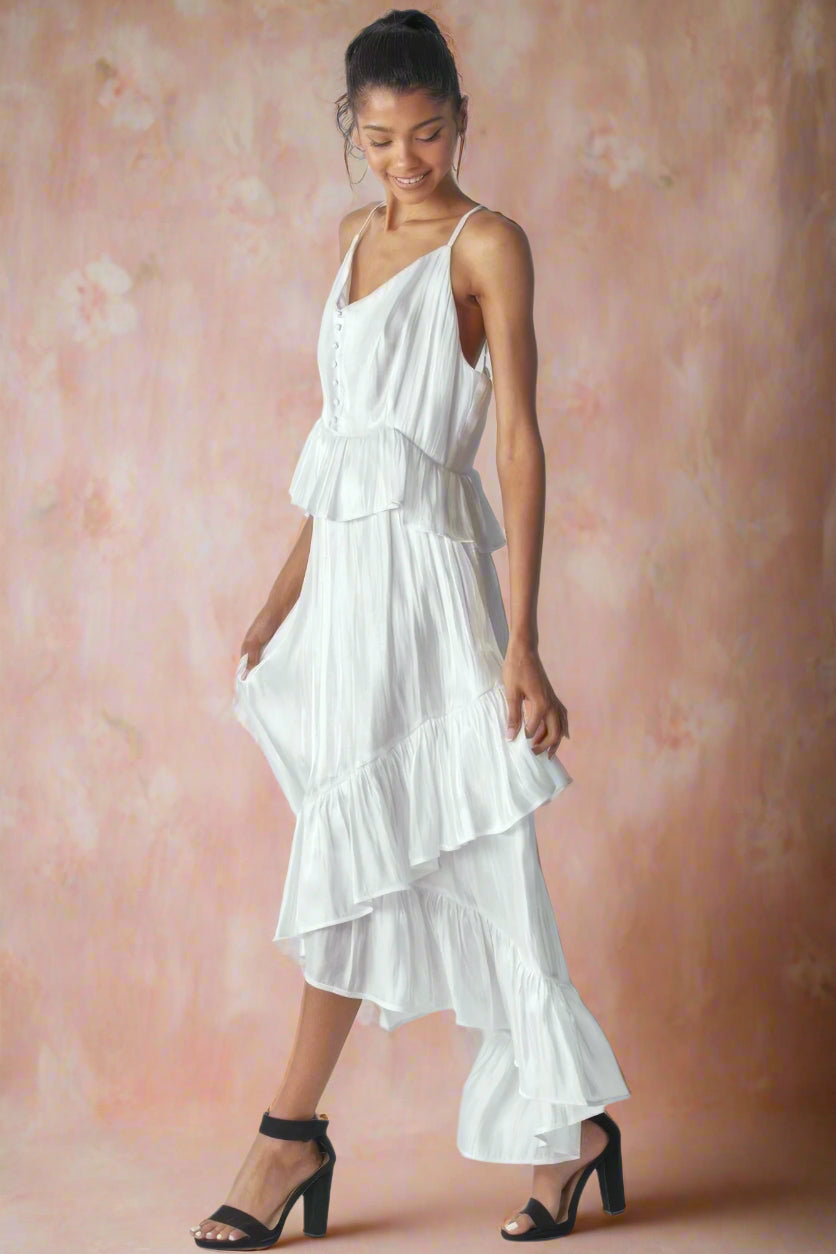 Ásta Modern Shimmering White Unstructured A-Line High-Low Maxi Wedding Dress With Spaghetti Straps, Ruffles, V-Neckline, Buttons, and Peplum Detail by Orange Blossom Bridal.