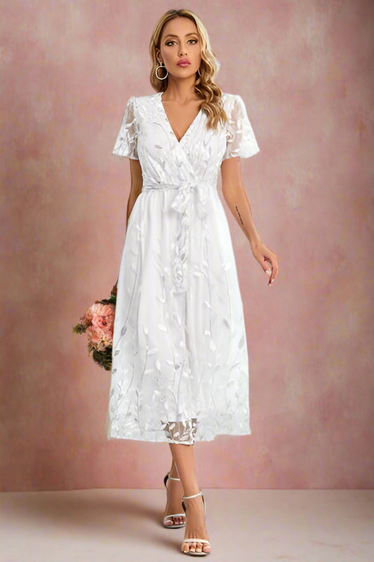 Aurora Sequin Embellished Embroidered Lace Faux Wrap White Midi Tea-length Wedding Dress with a Surplice Neckline, Illusion Short Sleeves, and Tie Waist Detail by Orange Blossom Bridal.